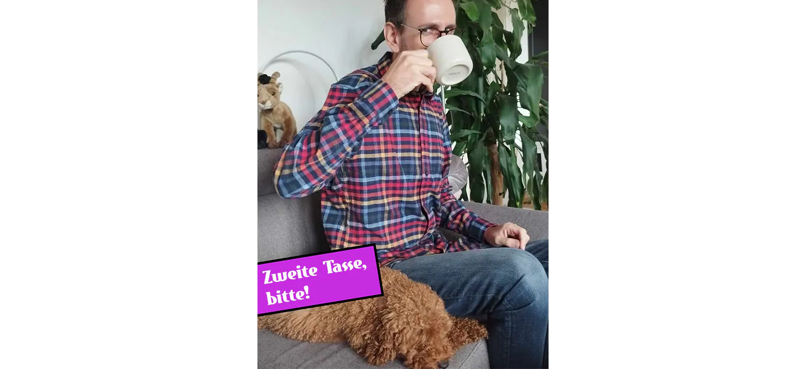 Torsten Gaitzsch trinkt auf einem Sofa eine Tasse Kaffee, neben ihm ein Hund