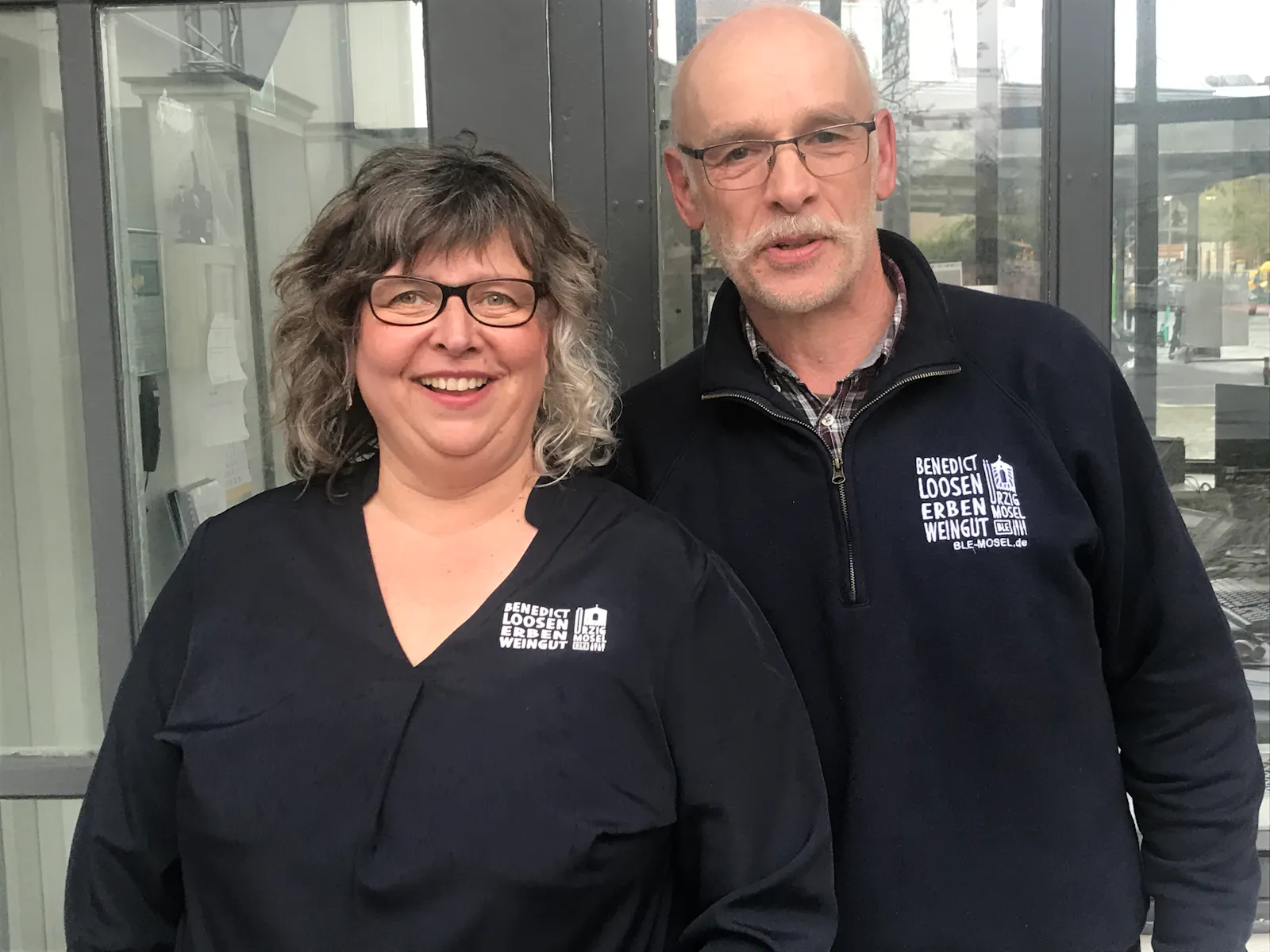 Claudia Müller und Bernhard Föhr vom Weingut Benedikt Loosen Erben stehen vor einem Pavillon in Berlin.