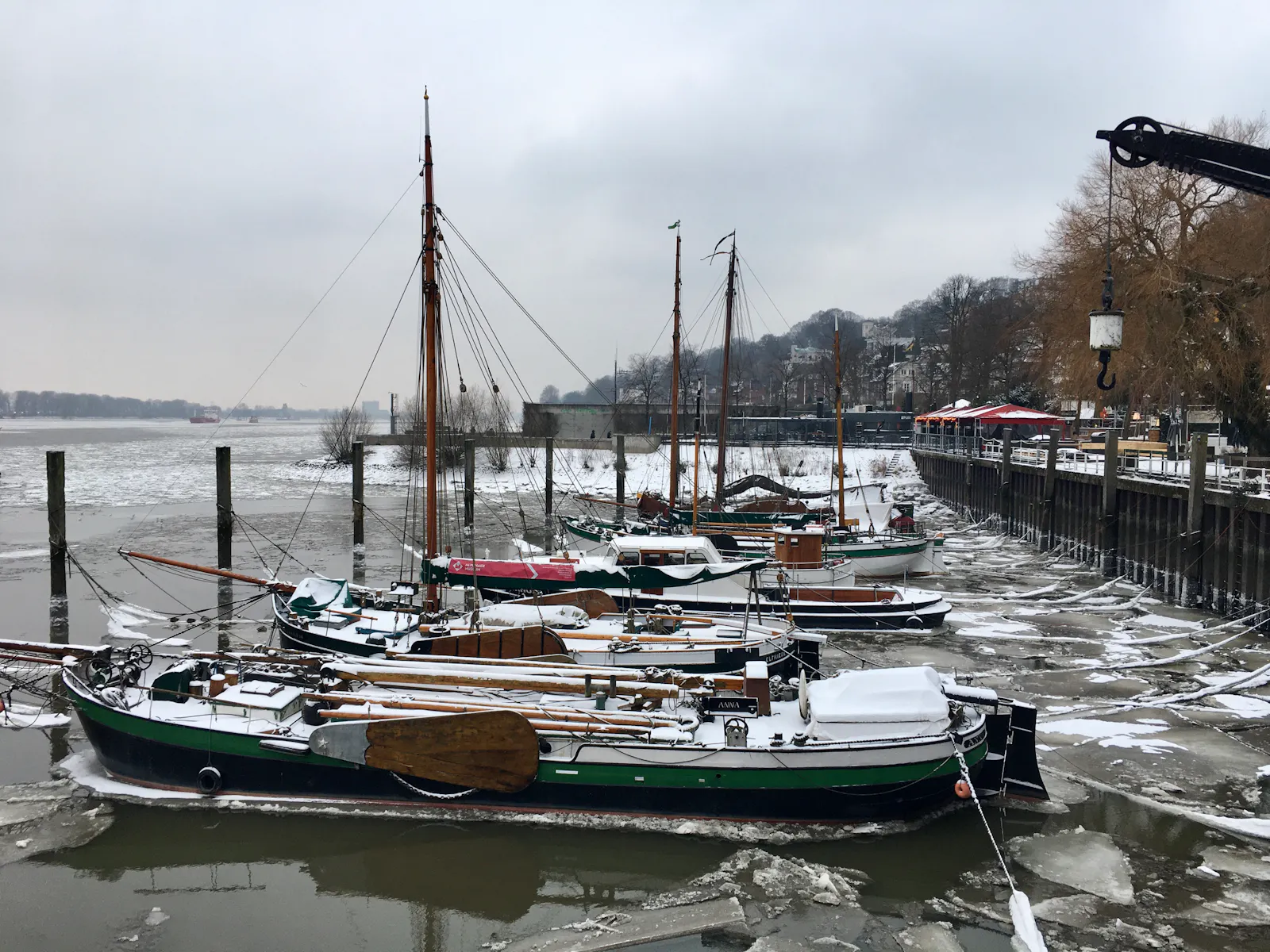 Kleine ältere Schiffe mit Eisschollen im Museumshafen