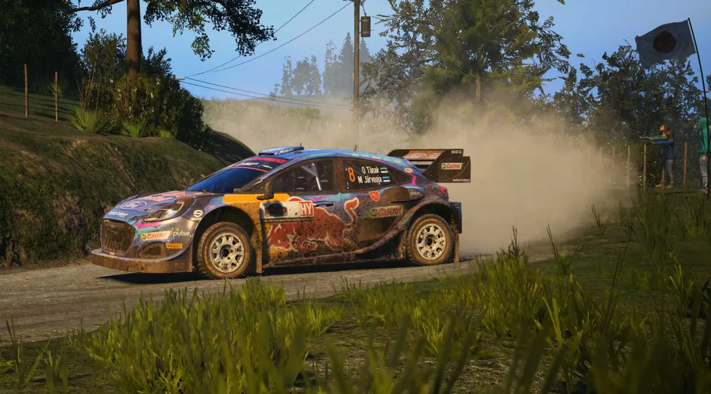 Ein Screenshot aus WRC 2023 mit eine, verschmutzten Rally-Wagen, der mit einer Staubfahne hinter sich in die Kurve geht.