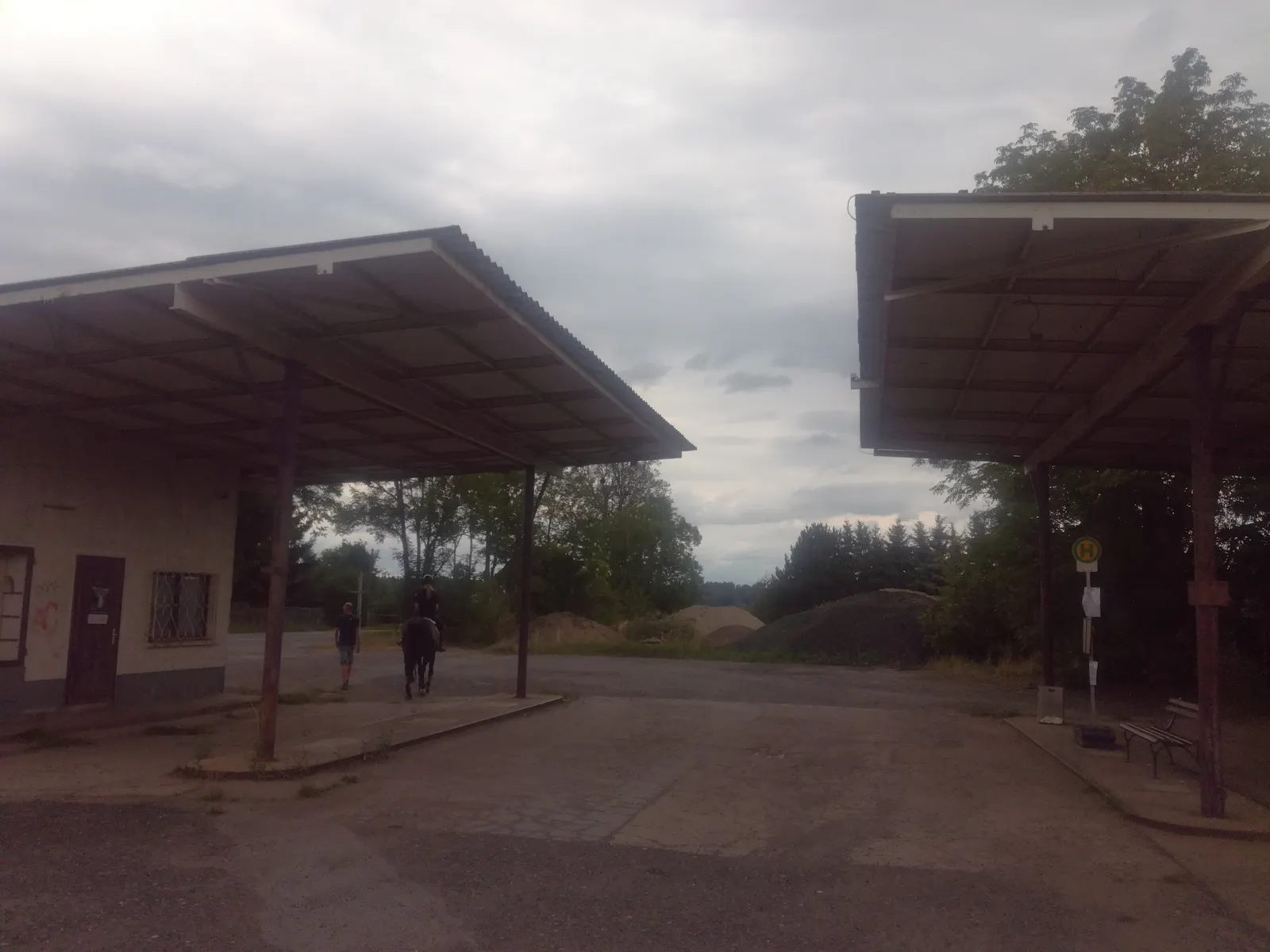 Haltestellenschild an einer stillgelegten Tankstelle.