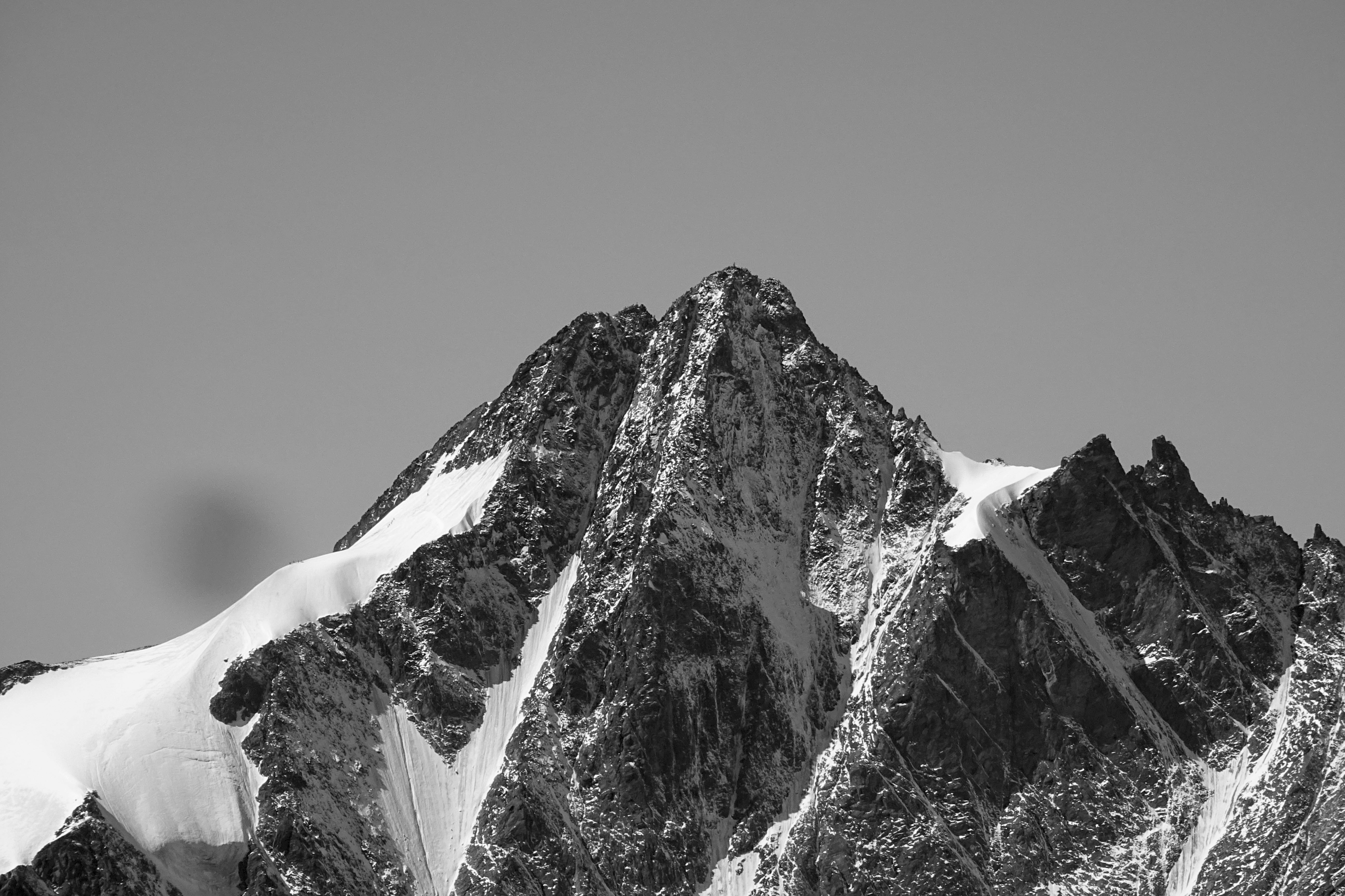 Schwarz-weiß-Aufnahme eines teilweise mit Schnee bedeckten Berges: Großes Wiesbachhorn, Fusch, Österreich. Veröffentlicht am 25. November 2017. Quelle: Unsplash/Tim Dennert
