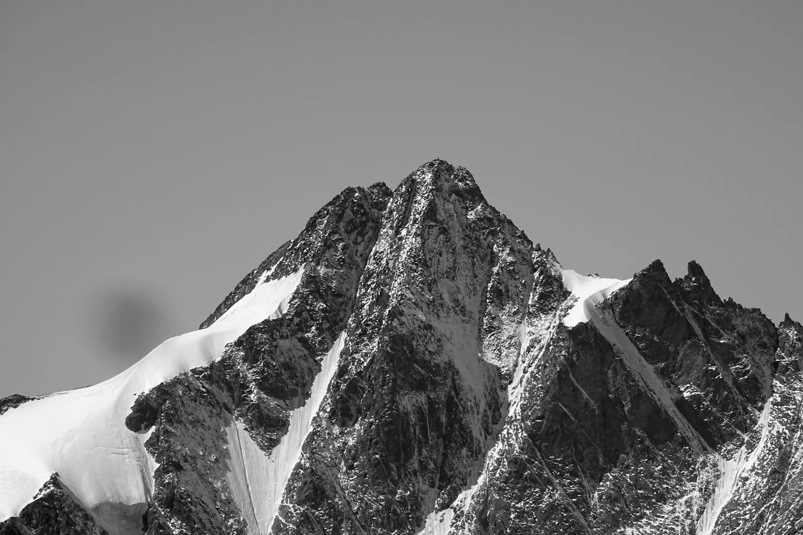 Schwarz-weiß-Aufnahme eines teilweise mit Schnee bedeckten Berges: Großes Wiesbachhorn, Fusch, Österreich. Veröffentlicht am 25. November 2017. Quelle: Unsplash/Tim Dennert
