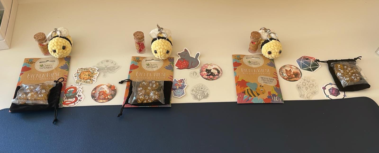 Geschenke wie Würfel, Bienchen-Schlüsselanhänger und Sticker.