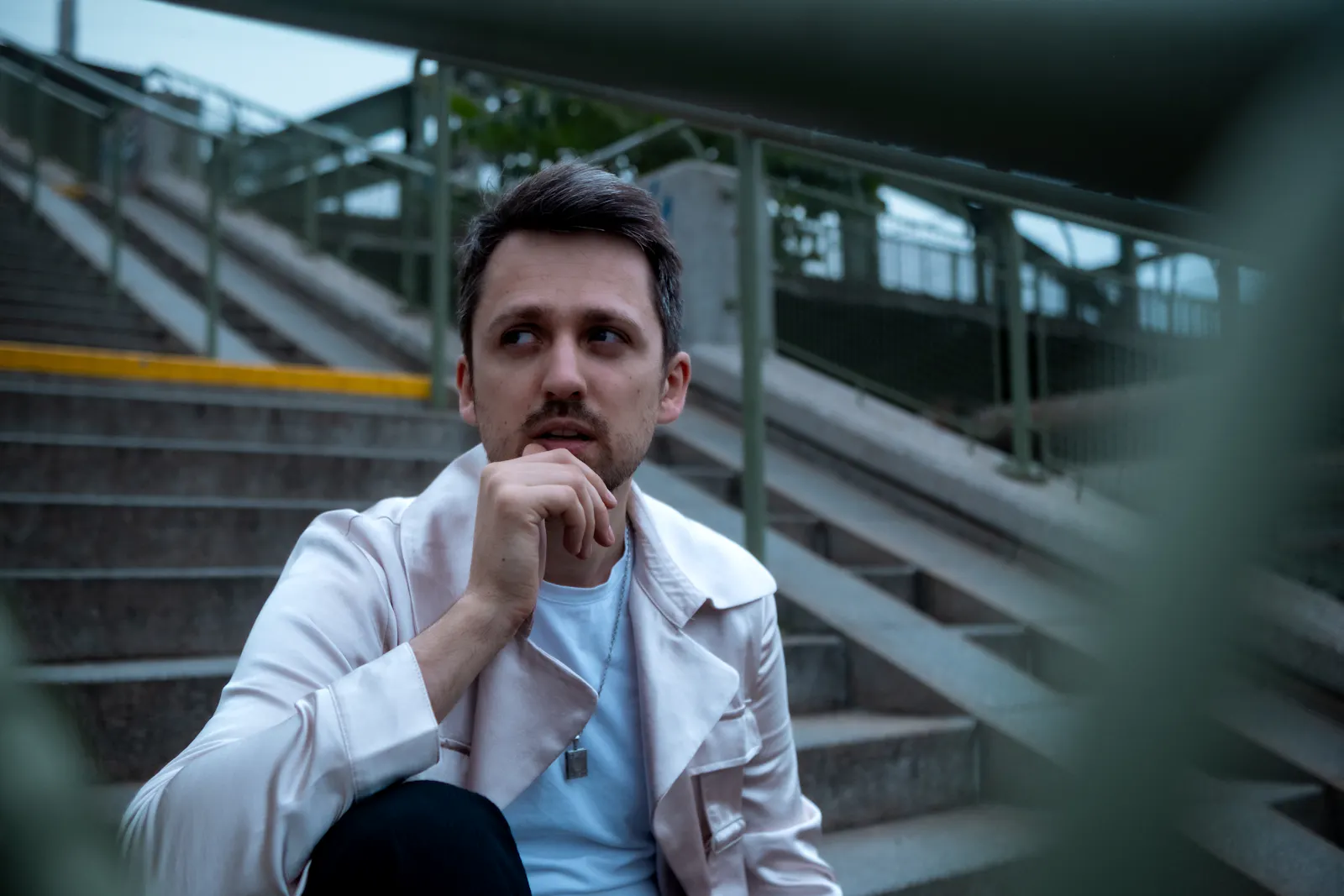 Fabian Navarro in seidenem Mantel auf einer Stiege