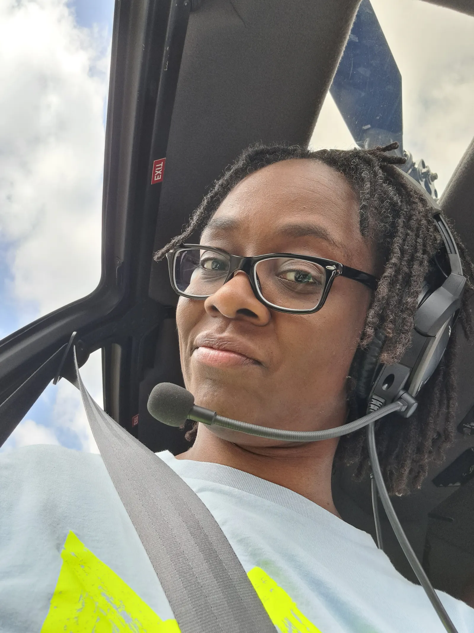 Selfie von Sharon, die in einem Hubschrauber sitzt und mit einem schiefen Lächeln in die Kamera schaut