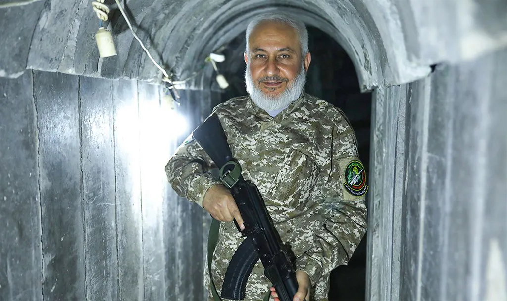 Ayman Mansour in einem Pressebild in Uniform mit einem Strumgewehr, lächelnd in einem typischen Hamas-Bunker.