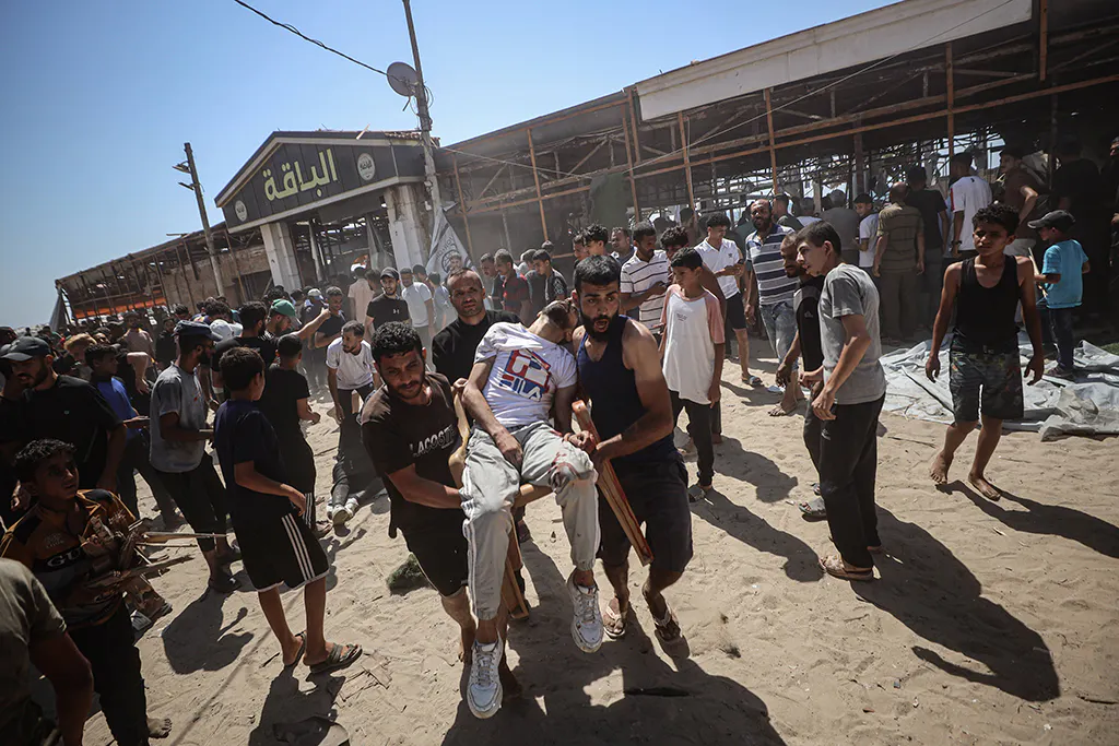 Ein Verletzter wird auf einem Stuhl aus dem Al Baqa getragen