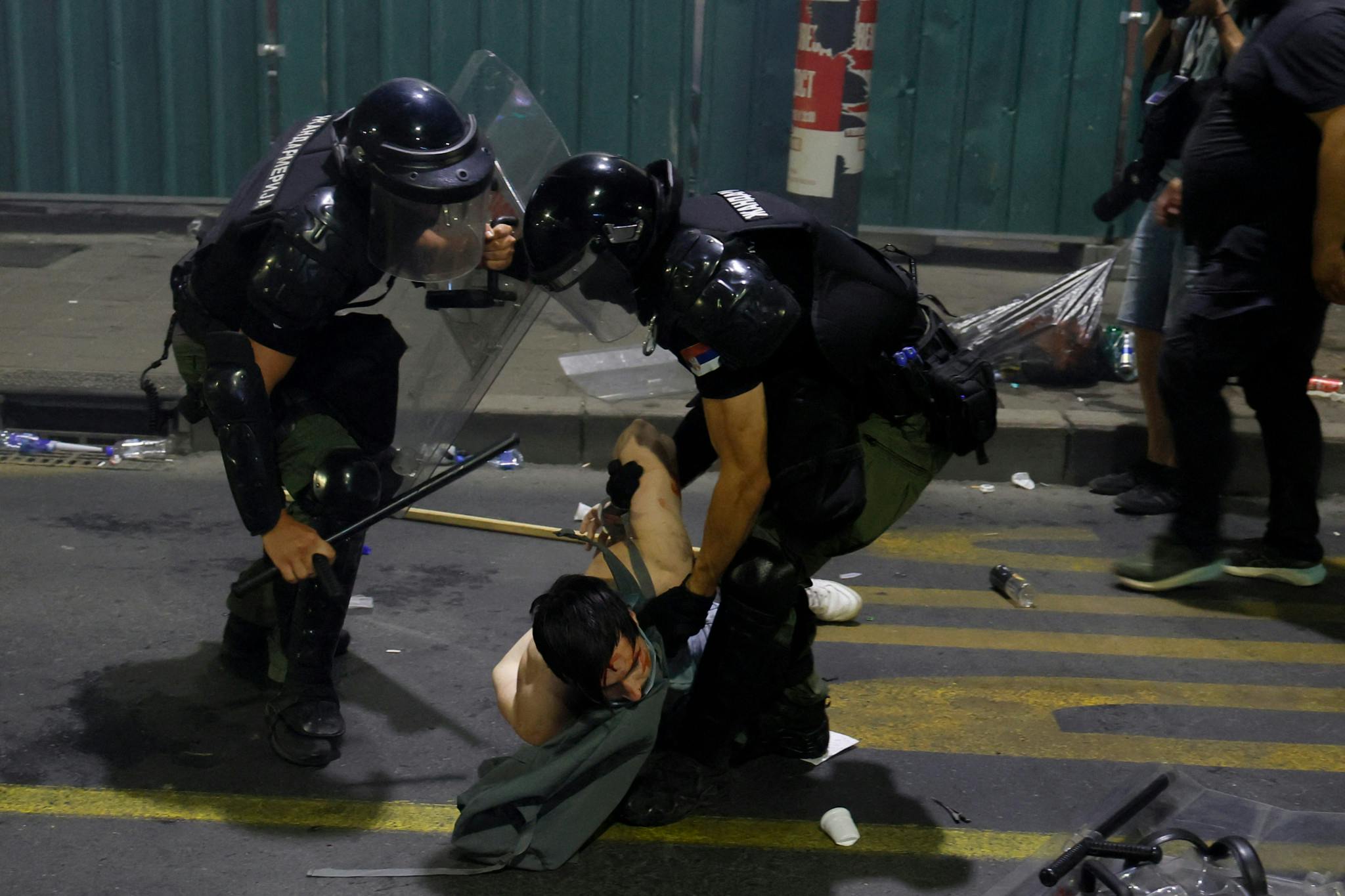 Polizeigewalt gegen einen auf dem Boden liegenden Protestierenden