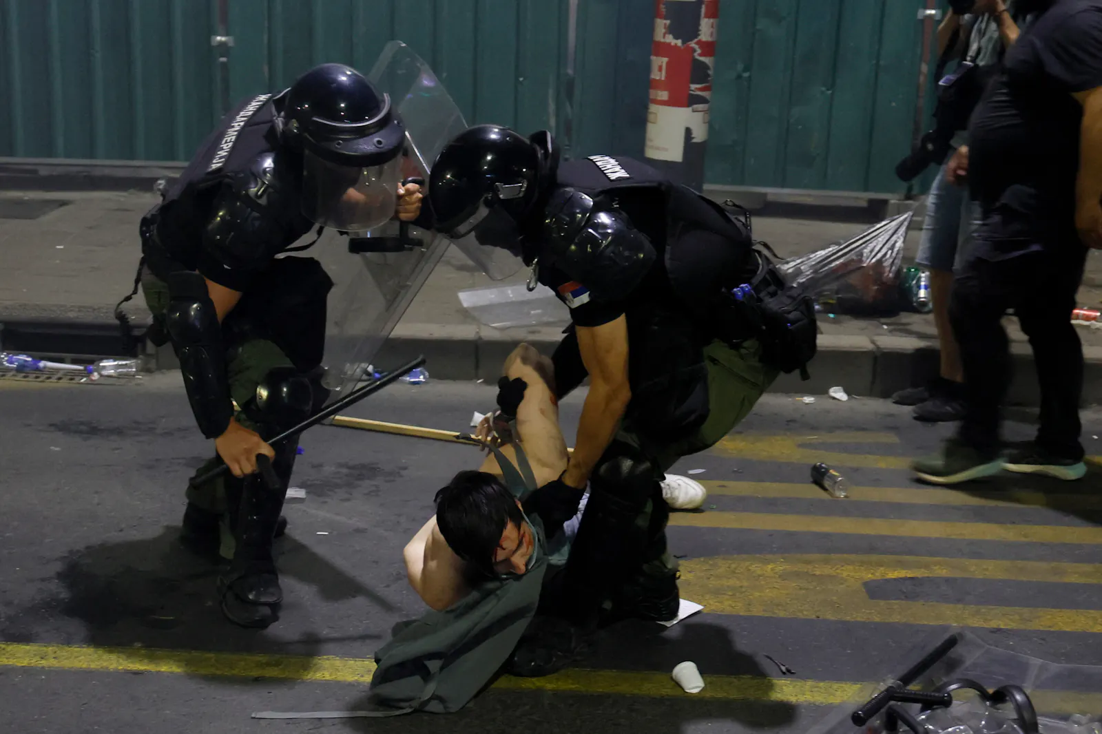 Polizeigewalt gegen einen auf dem Boden liegenden Protestierenden