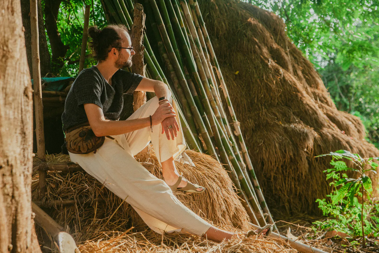 Olaf sitzt auf einem Heuballen in der Natur und schaut in die Ferne.