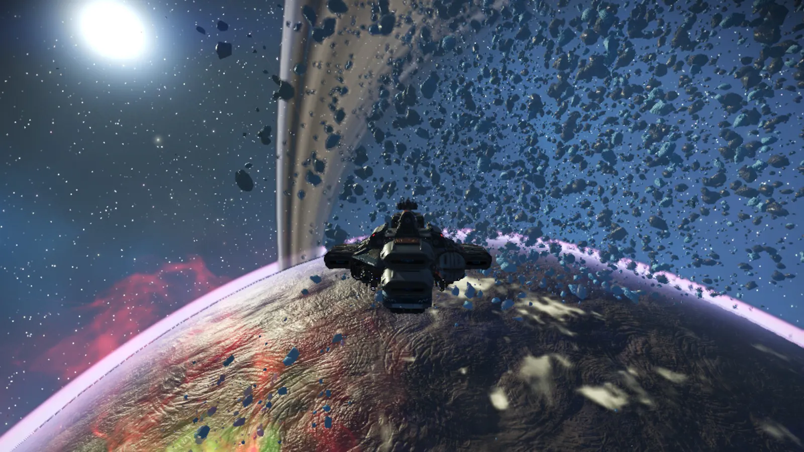Ein Asteroidengürtel in No Man's Sky um einen Planeten, der von roten Gasen umgeben ist, im Hintergrund leuchtet eine Sonne.