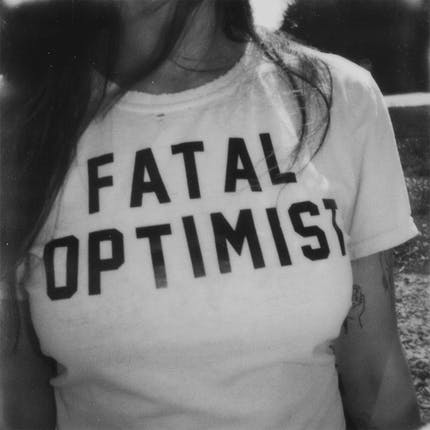 weißes Tshirt, schwarze Schrift: fatal optimist