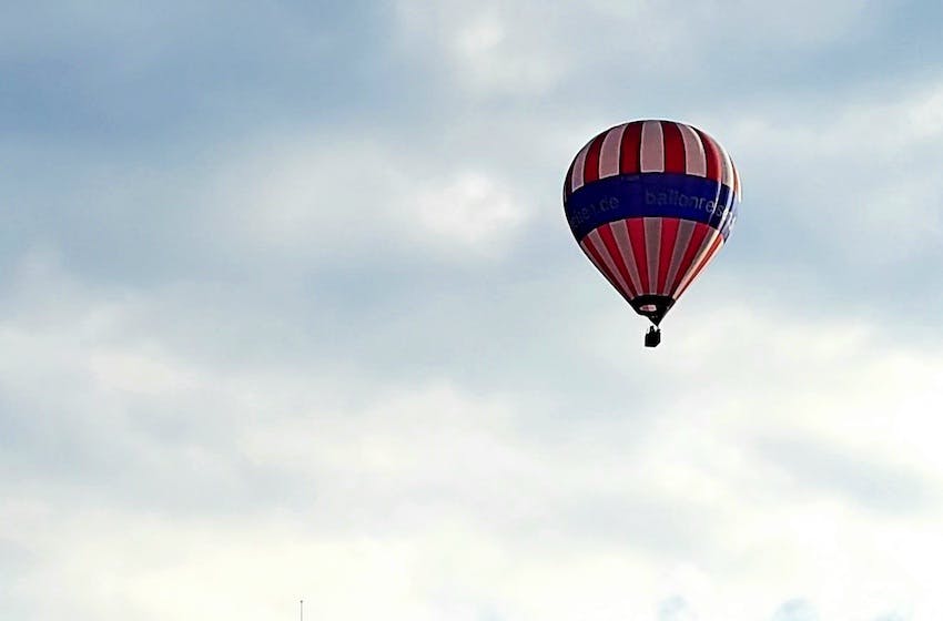rot-blauer Heißluftballon im Abendhimmel mit Wolken