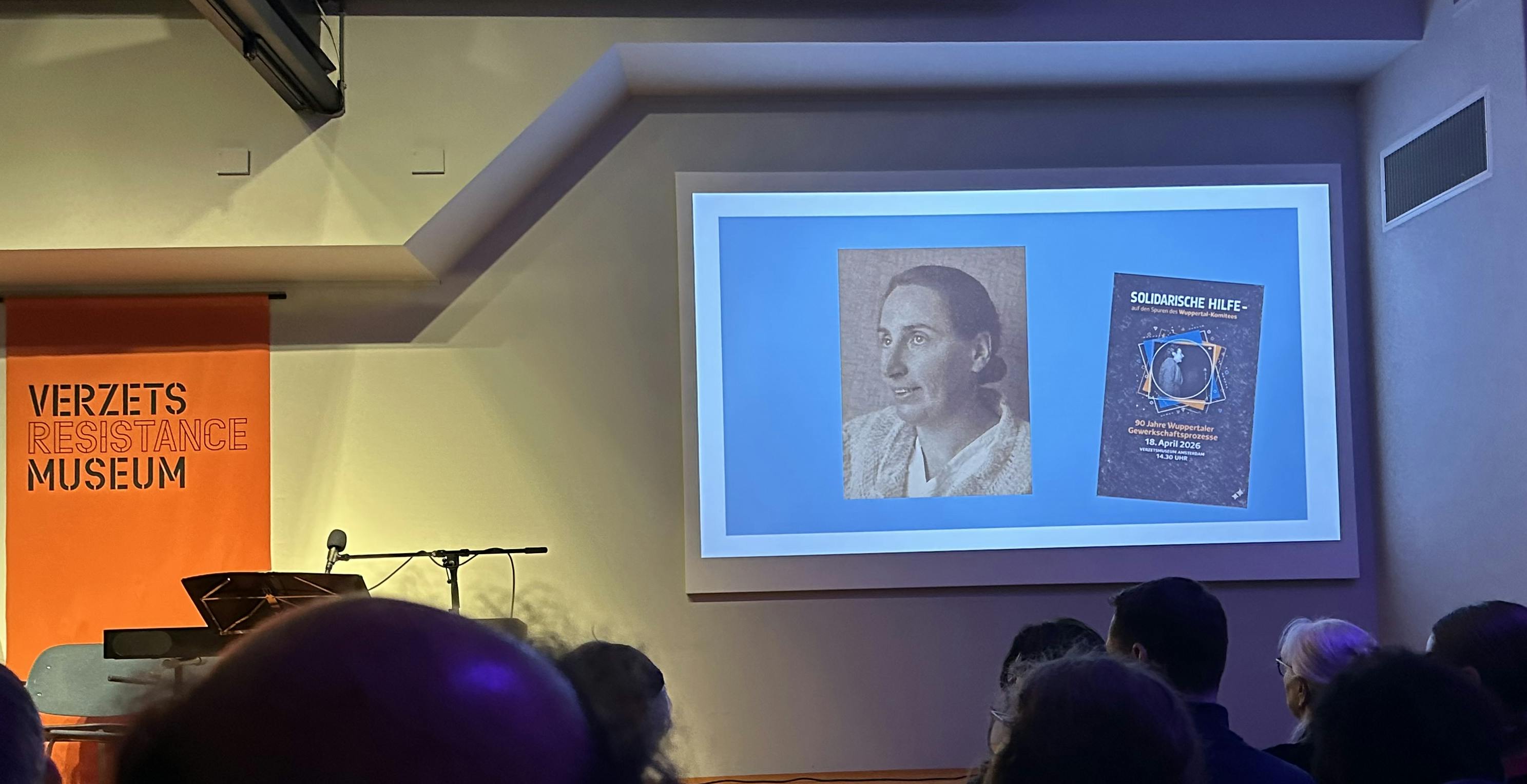 Auf einer Leinwand in einem gut besuchten Saal ist ein Bild der niederländischen Jüdin Selma Meyer zu sein, eine Frau Mitte 30 mit zurückgekämmten dunklen Haaren, die im Nacken zu einem Knoten gesteckt sind. Sie ist schräg von der linken Seite fotografiert, lächelt ganz leicht und schaut nach schräg oben.