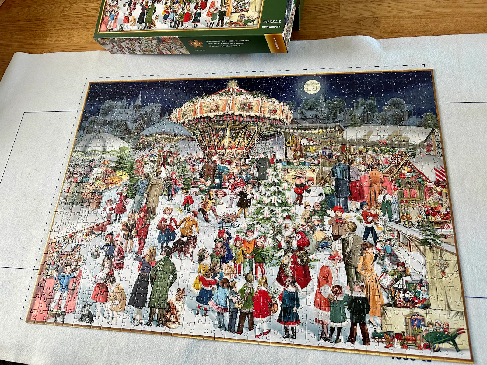 Puzzlematte auf einem Tisch, darauf das fertig gepuzzelte Puzzle "Nostalgischer Weihnachtsmarkt"