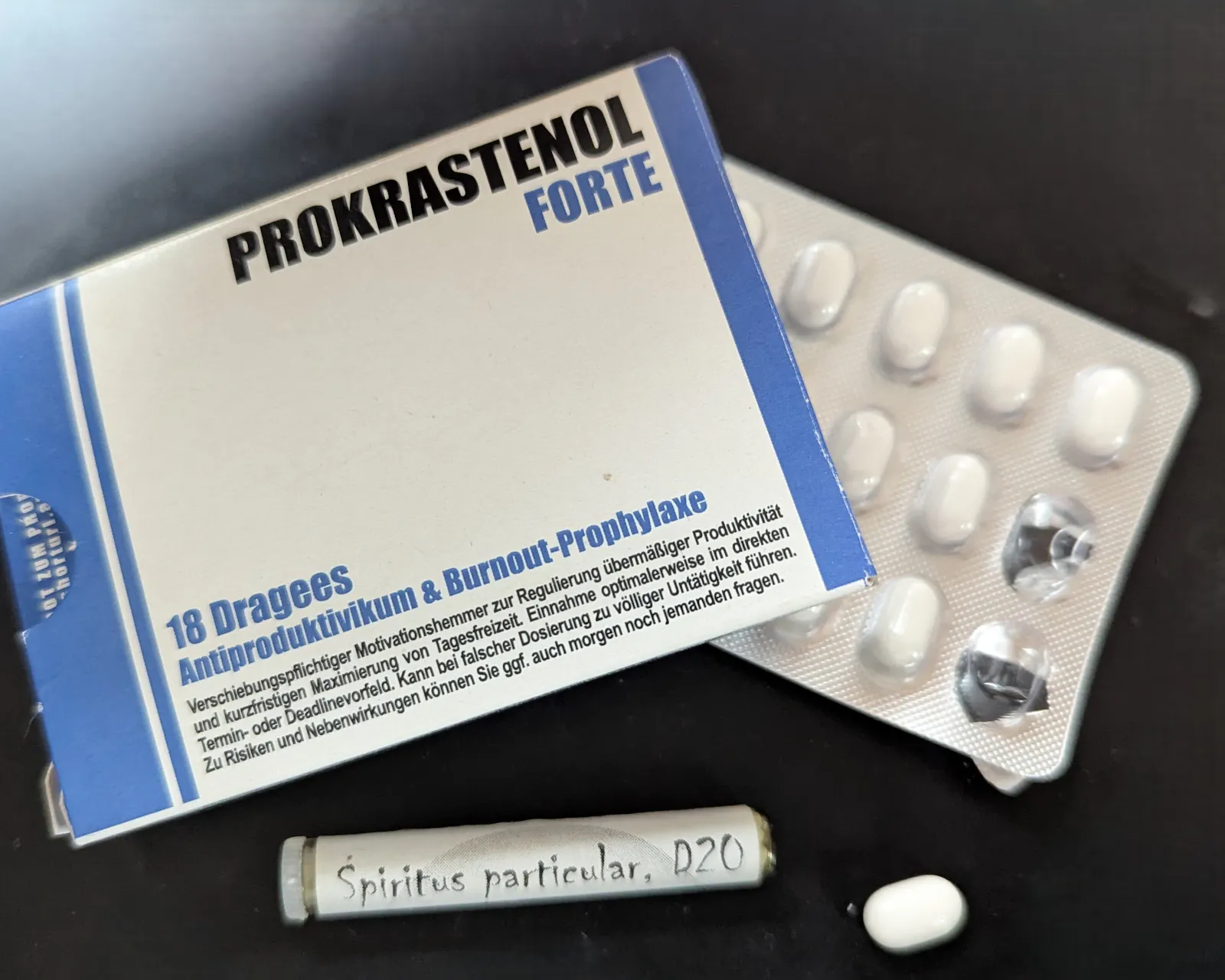 Medikamentenpackung, Aufschrift: Prokrastinol Forte und ein Röhrchen, Aufschrift: Spiritus particular D20