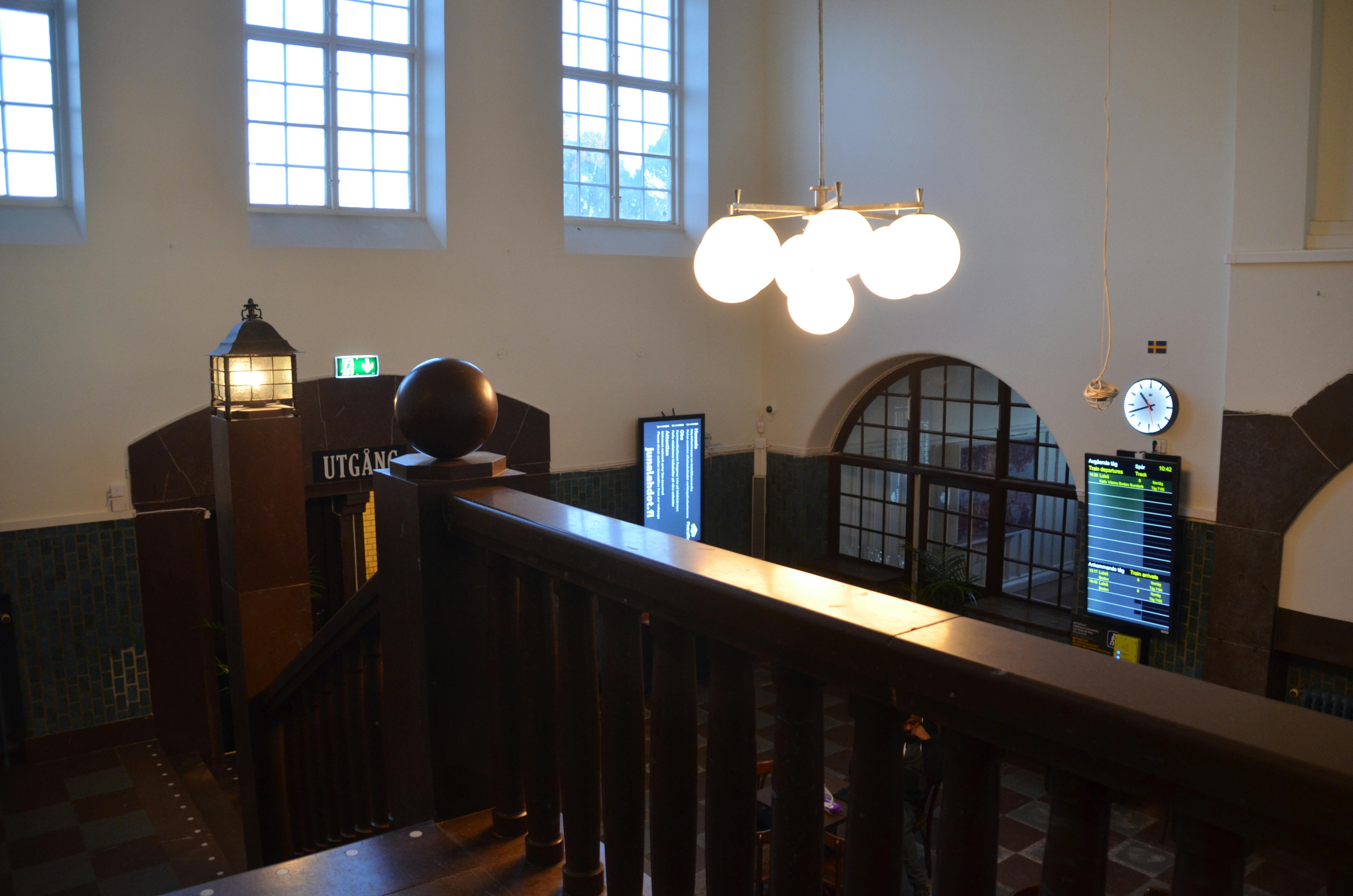 Gebäude innen mit Lampen, Treppengeländer, Anzeigentafeln