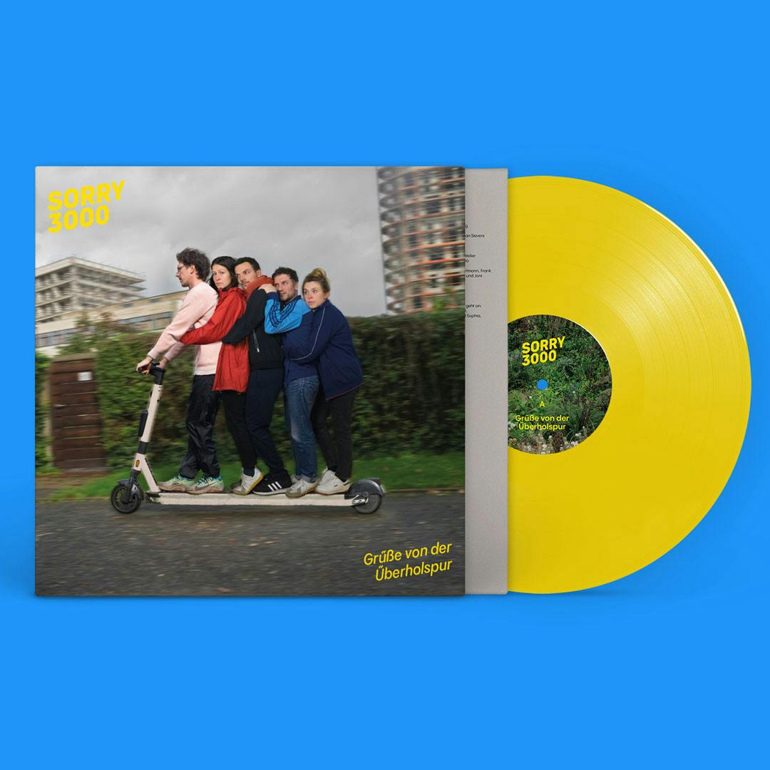 Vinyl record with yellow disc and cover showing five people standing on a scooter in a row on a street with buildings in the background