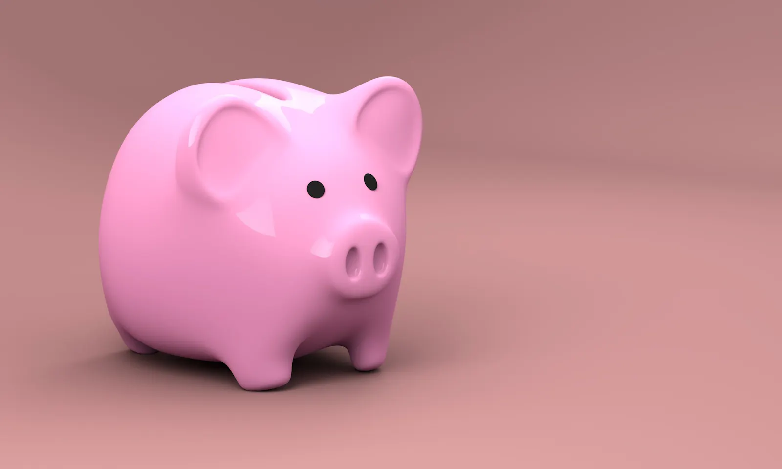 ein kleines rosa Sparschwein auf braunem Grund