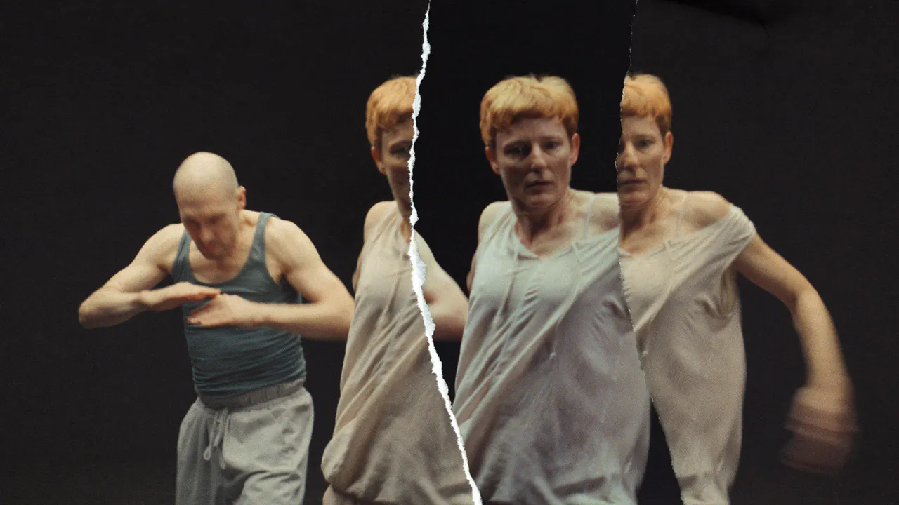 Filmstill aus dem Film Fassaden. Abgebildet sind eine Tänzerin und ein Tänzer in Bewegung. Über das Bild zieht sich ein Riss. Die Tänzerin ist mehrmals zu sehen, so als wären verschiedene zerrissene Fotos übereinander gelegt worden.
