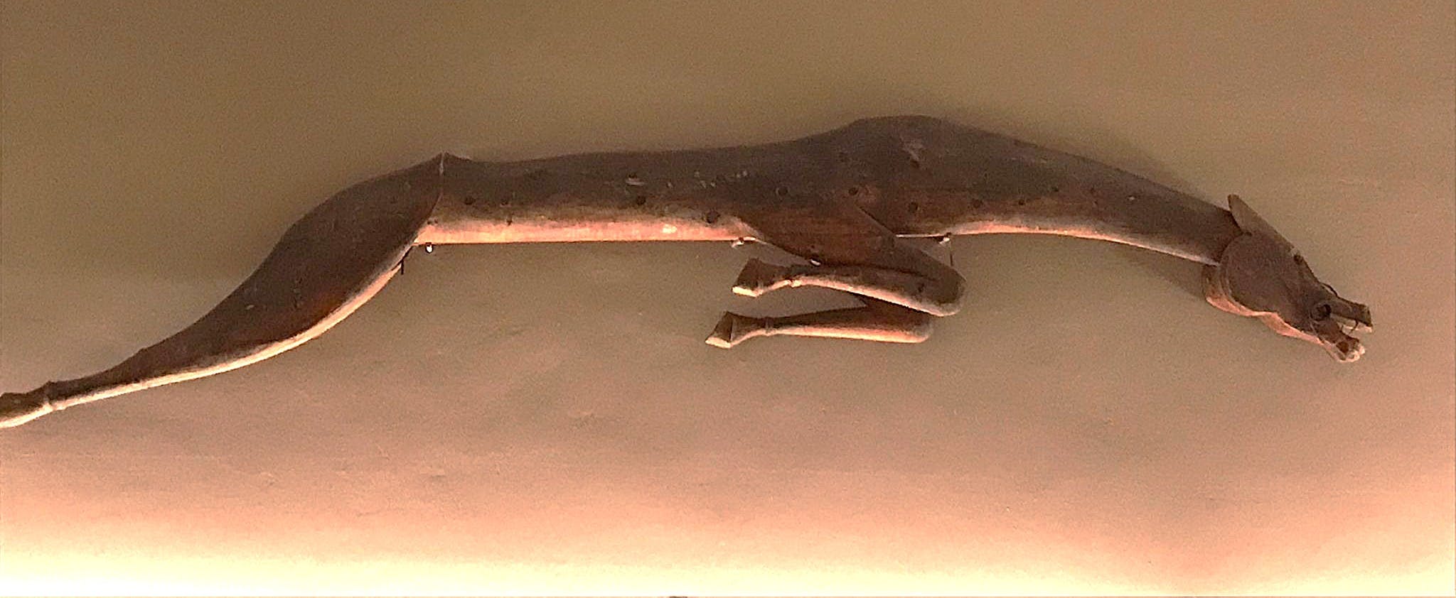 figura scolpita di cavallo stilizzato che salta appeso su parete