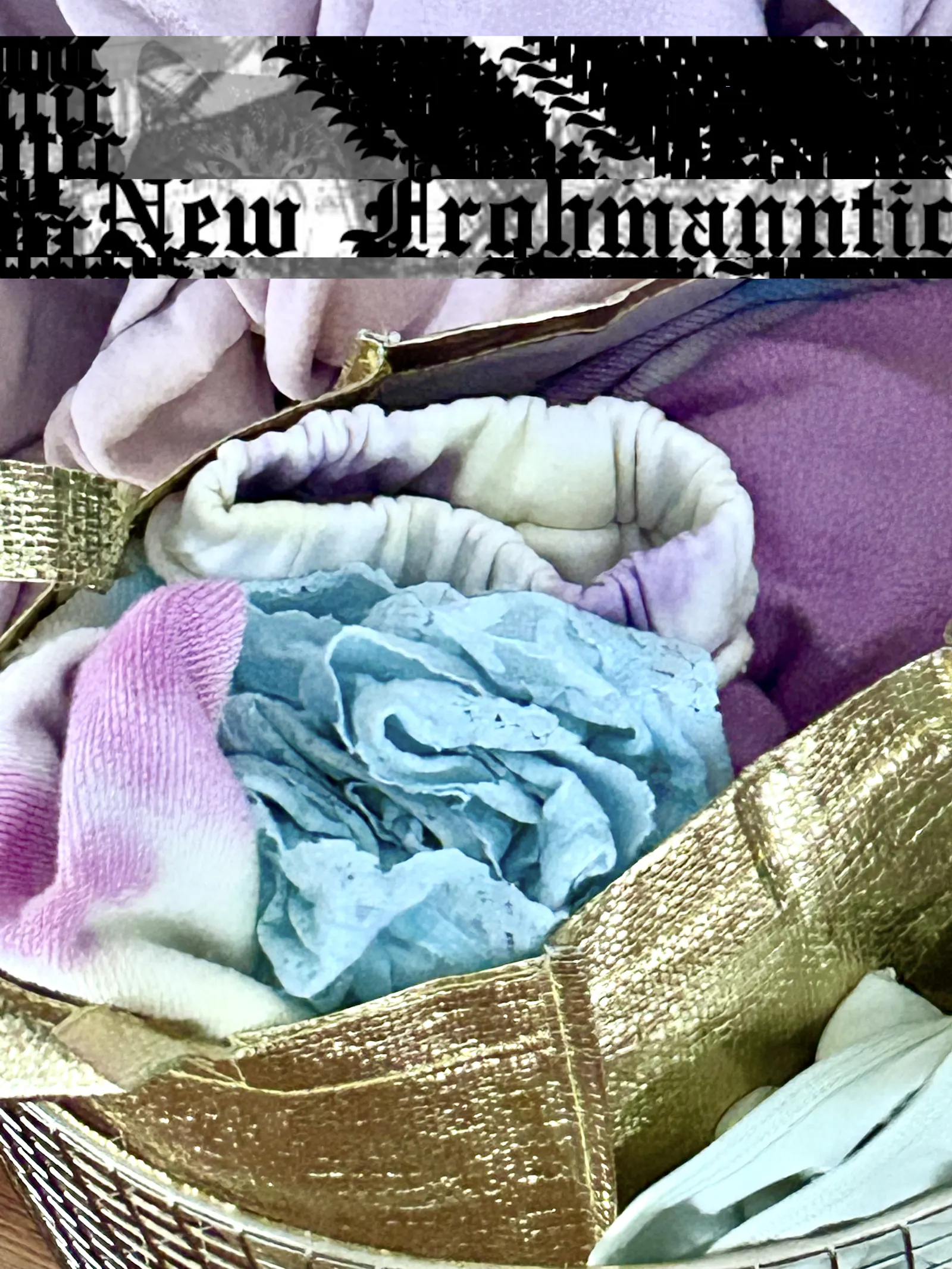Wäschekorb mit pastellfarbener Kleidung, New-Frohmanntic-Schriftzug