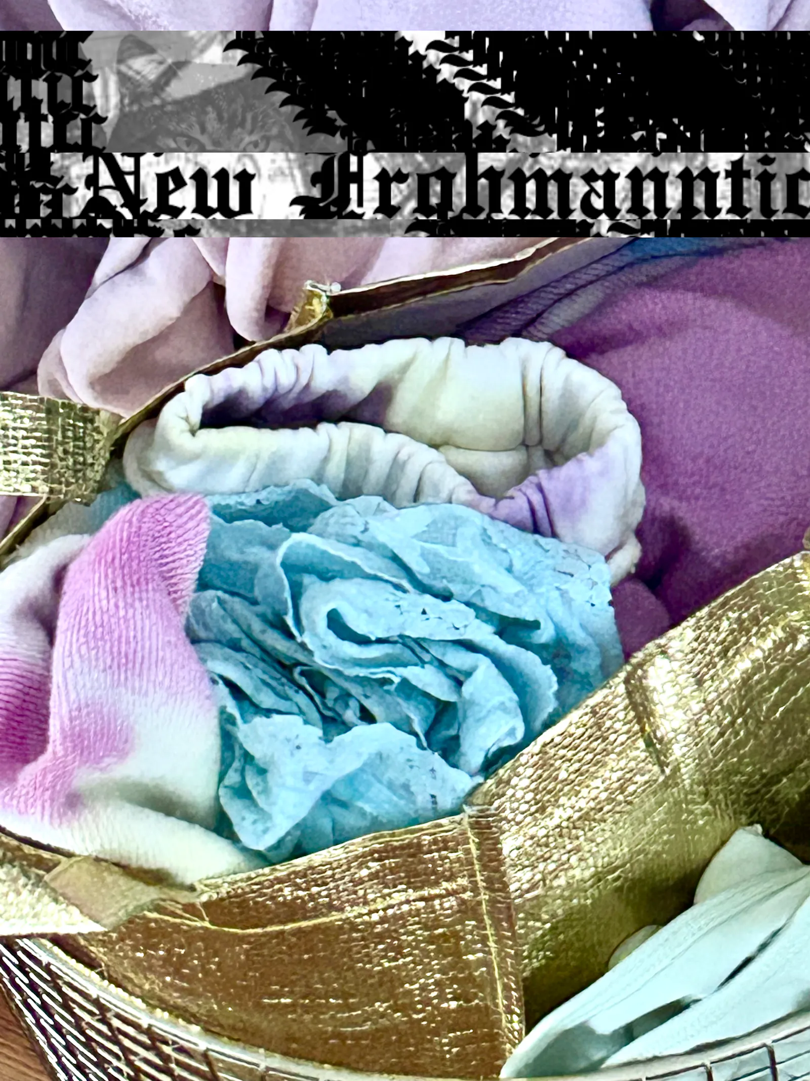 Wäschekorb mit pastellfarbener Kleidung, New-Frohmanntic-Schriftzug