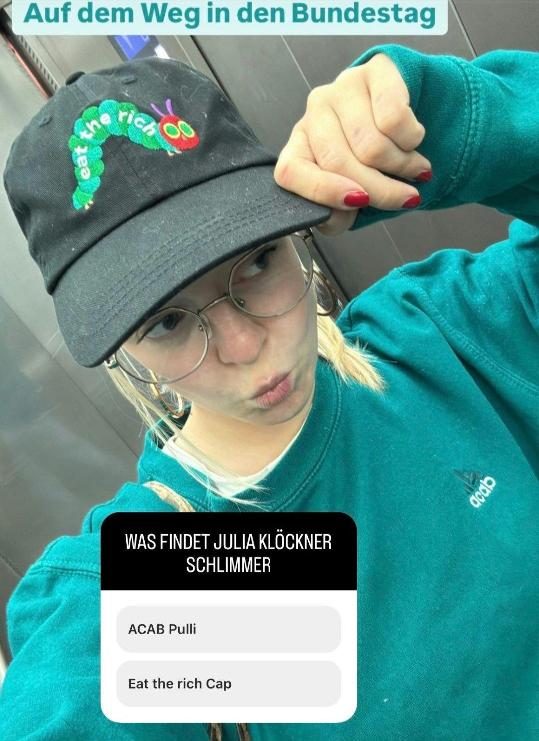 Screenshot von Instagram, Jette Nietzard formt auf einem Aufzugselfie einen Schmollmund, zieht mit der linken Hand die Kappe zurecht.

Textfelder:
"Auf dem Weg in den Bundestag"

Abstimmungstool: "Was findet Julia Klöckner schlimmer"
a) ACAB Pulli
b) Eat the rich Cap
