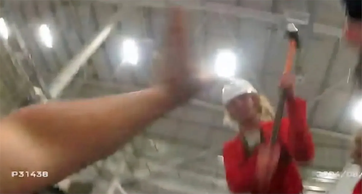 Screenshot aus dem Video der Body Cam: Corner holt aus, die Polizistin reckt die Hand entgegen.
