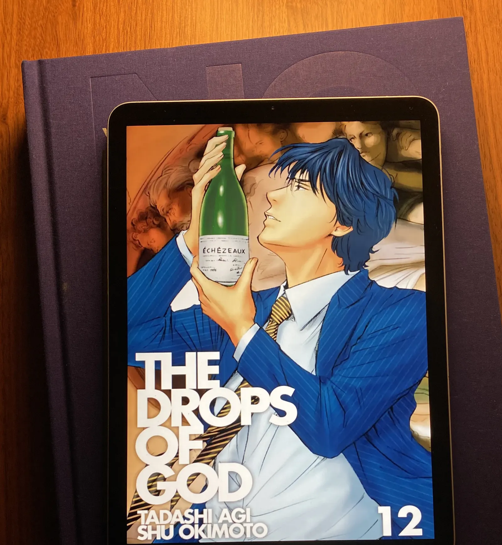 Auf dem iPad ist das Cover des zwölften Teils des Mangas Drops of God zu sehen.