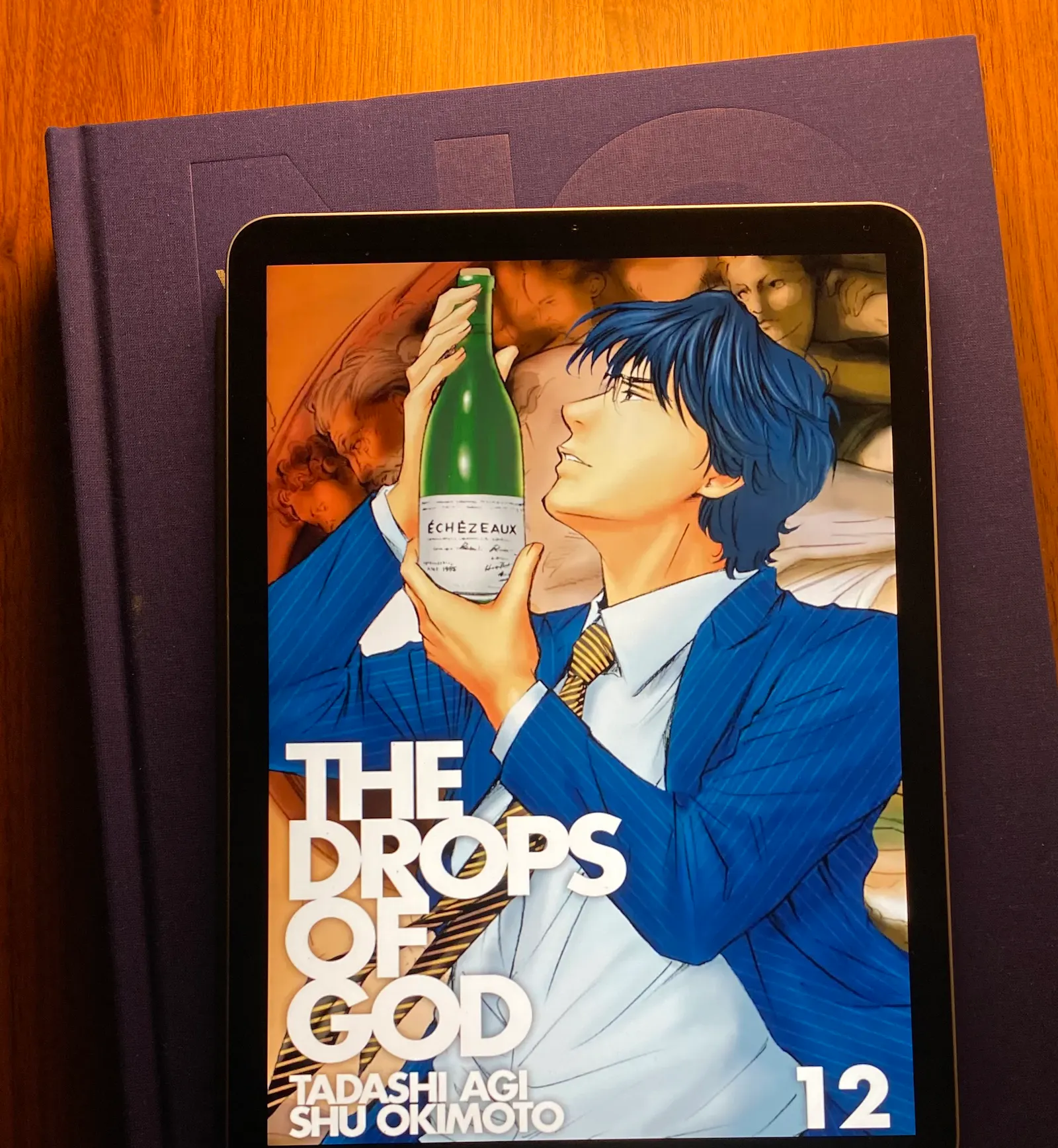 Auf dem iPad ist das Cover des zwölften Teils des Mangas Drops of God zu sehen.