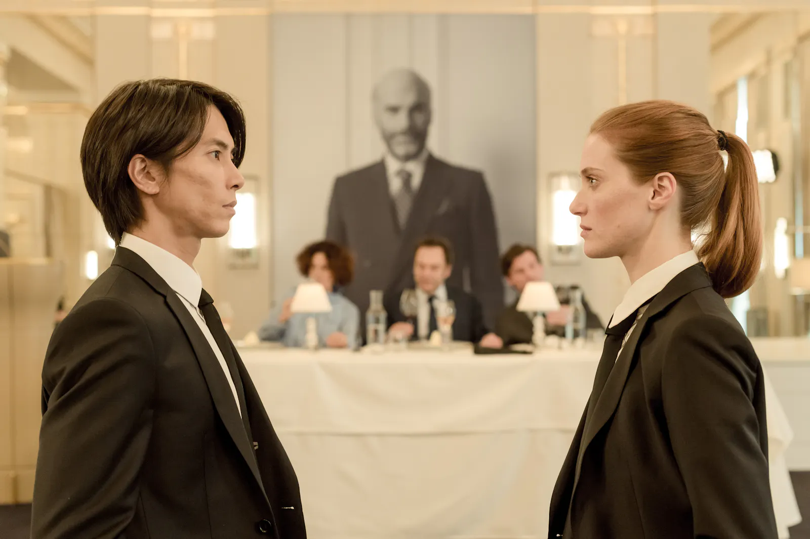 In dieser Filmszene stehen sich die Schauspieler Tomohisa Yamashita und Fleur Geffrier gegenüber und schauen sich misstrauisch an.