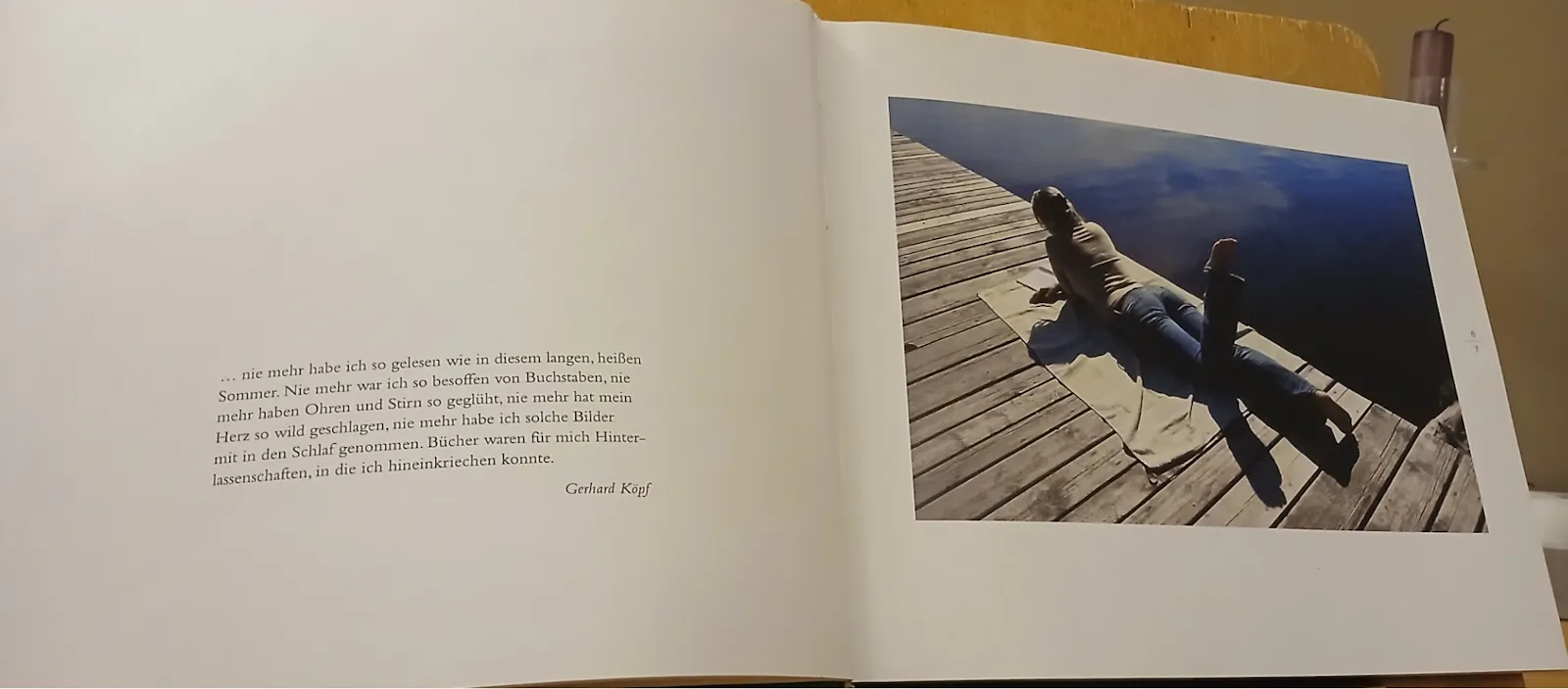 Ein Buch im Querformat. Links ein kurzer Erinnerungstext über das Lesen in einem heißen Sommerurlaub. Rechts, ein farbiges Foto, mit einer Frau, die bäuchlings auf einem Bootssteg liegt und liest.