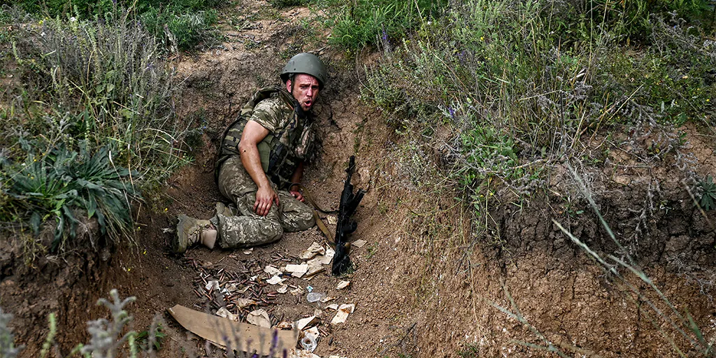 Ukrainischer Soldat mit alter Ausrüstung in einem Graben.