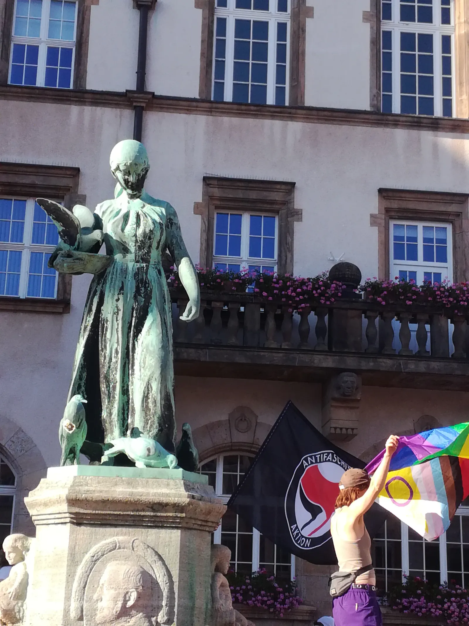 CSD Döbeln: Zwischenkundgebung am Obermarkt Döbeln; Demonstratinnen mit Fahnen am Schlegelbrunnen