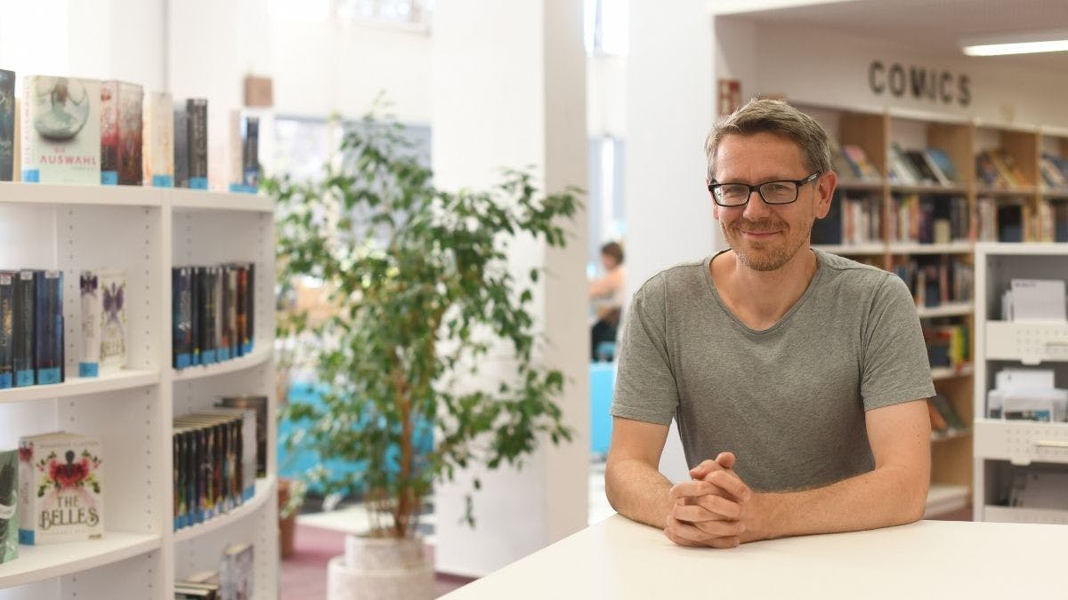 Das Bild zeigt den Bibliothekar Tim Schumann in der Heinrich-Böll-Bibliothek Pankow