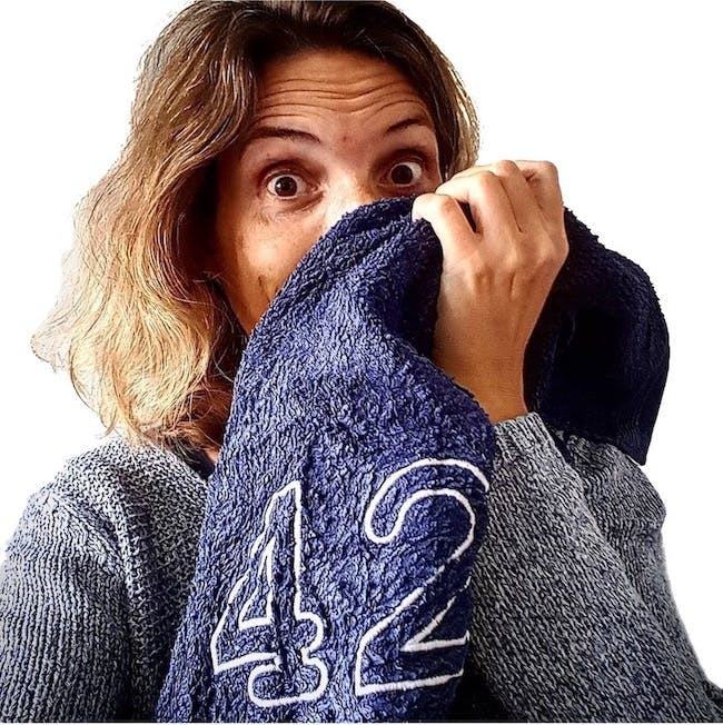 Christine Piontek mit einem blauen Handtuch, auf dem eine gestickte 42 zu sehen ist.
