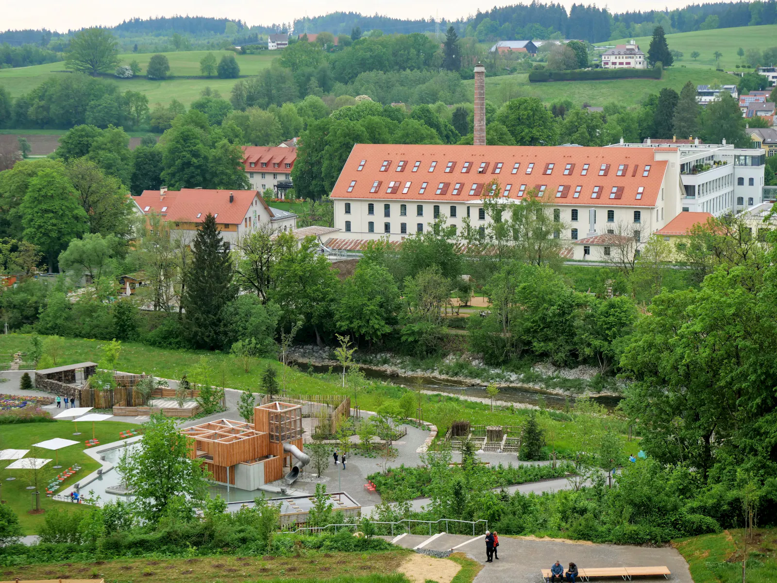 So sieht das Spinnerei-Areal heute aus: Der Schornstein steht noch, in den Spinnerei-Gebäuden wird heute gearbeitet und gewohnt. Im Vordergrund ein Teil des Gartenschau-Geländes. Foto: Jürgen Brand