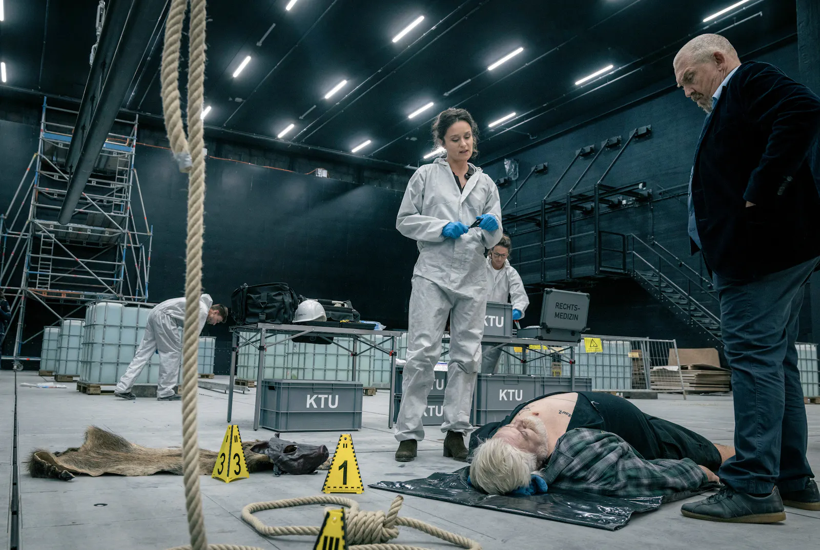 Die KTU-Leiterin Natalie Försten (Tinka Fürst) hat den zweiten Leiche untersucht. Und auch hier ist der Fundort nicht Tatort, erklärt sie Kommissar Freddy Scheink (Diermar Bär). Bei dem Toten handelt es sich um den Schuhmacher Willi Köpke (Aljoscha Stadelmann).
© WDR/Thomas Kost