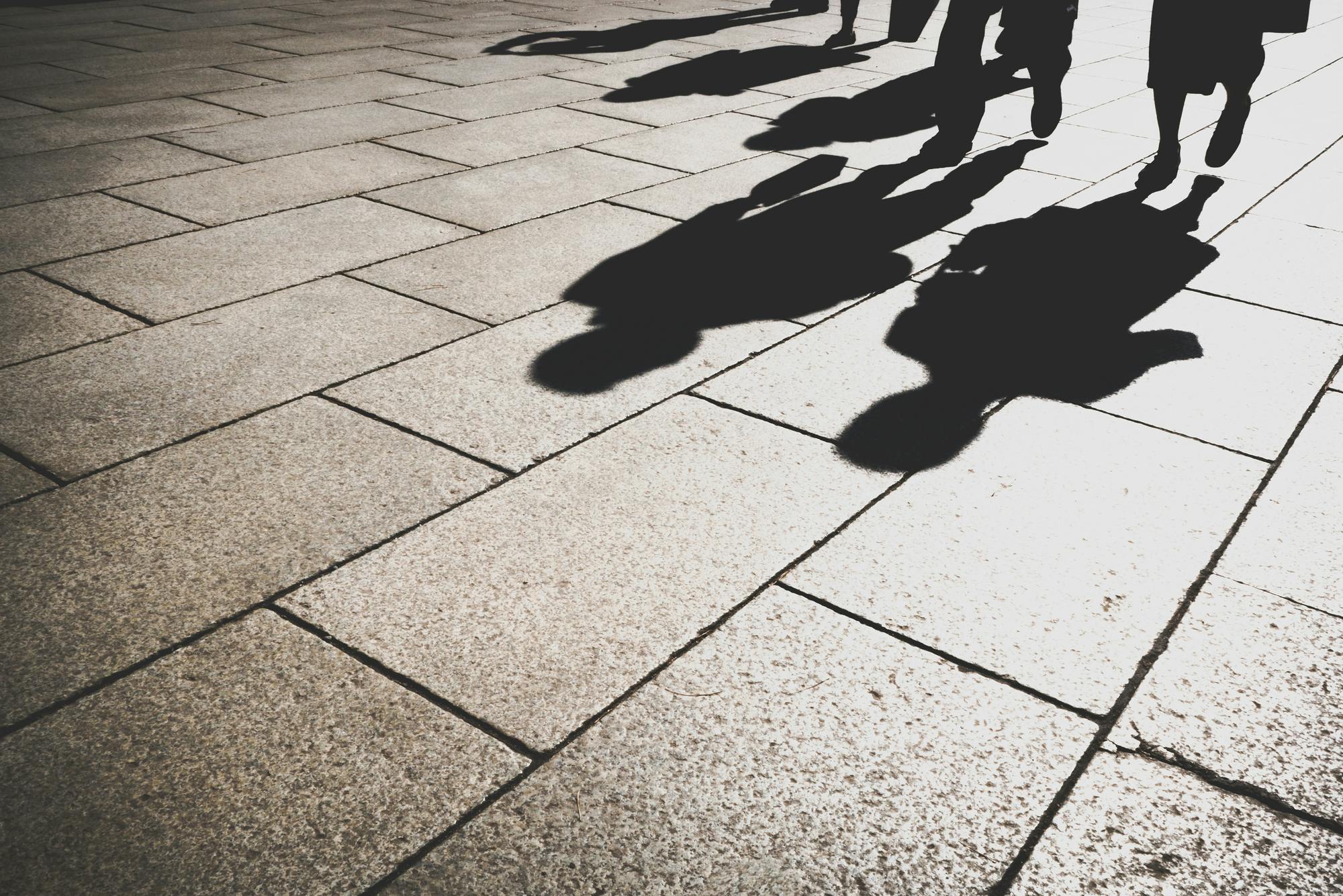 Schatten des Beamten im Tageslicht auf der Granitstraße (seine Schatten vorauswerfen)