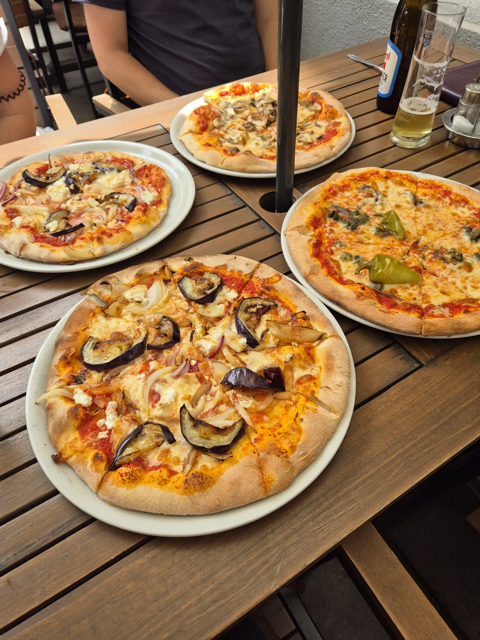 Vier Pizzen sind auf einem Tisch.