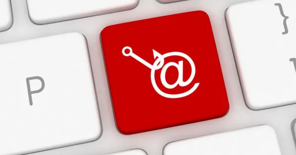 Computer-Tastatur mit roter "@"-Taste, auf der ein Angelhaken - symbolisch für Phishing - abgebildet ist. / Bild: Canva