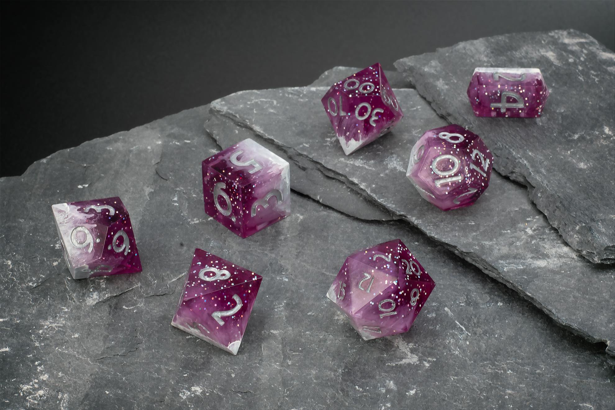 Violett-transparentes Polyeder-Würfelset mit feinen Glitzerpartikeln und silberfarbenen Zahlen.