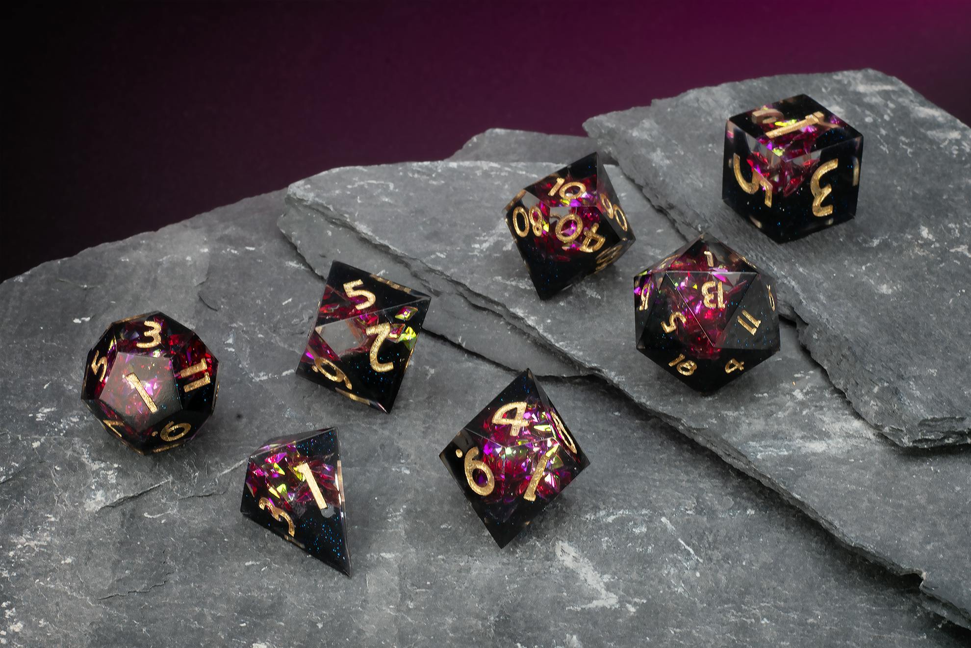 Schwarz-transparentes Geoden-Würfelset mit rot-violetten Glitzerpartikeln und goldenen Zahlen.