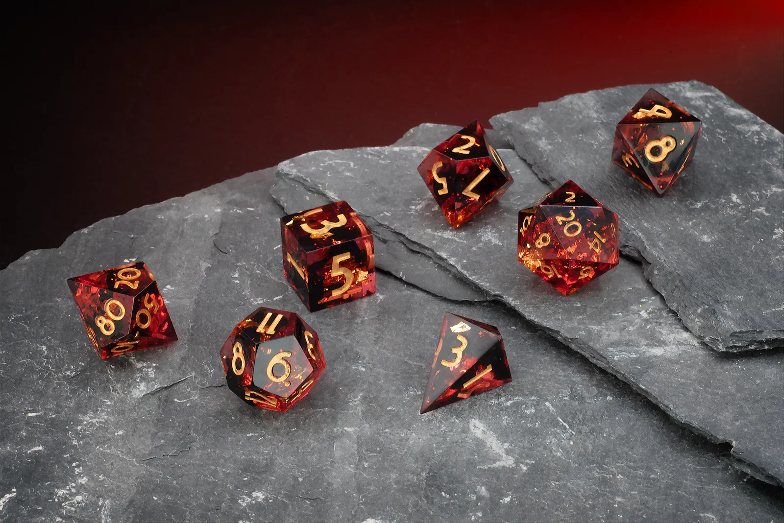 Rot-transparentes Polyeder-Würfelset mit goldenen Zahlen und feinen Glitzerpartikeln.