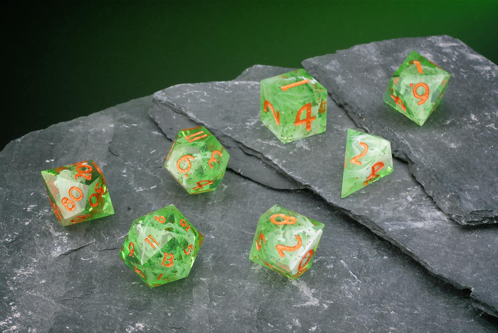 Grün-transparentes Polyeder-Würfelset mit feinen Einschlüssen und orangefarbenen Zahlen.