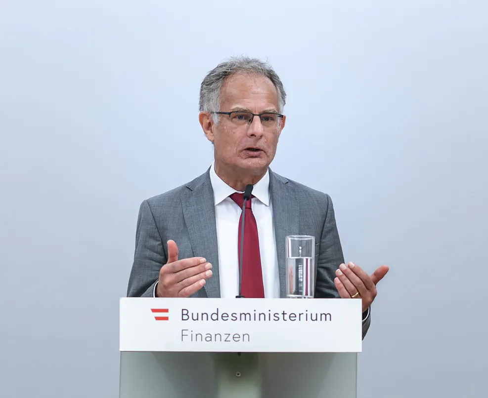 Das Bild zeigt Finanzminister Markus Marterbauer (SPÖ) bei einer Pressekonferenz am Rednerpult des Bundesministeriums für Finanzen.