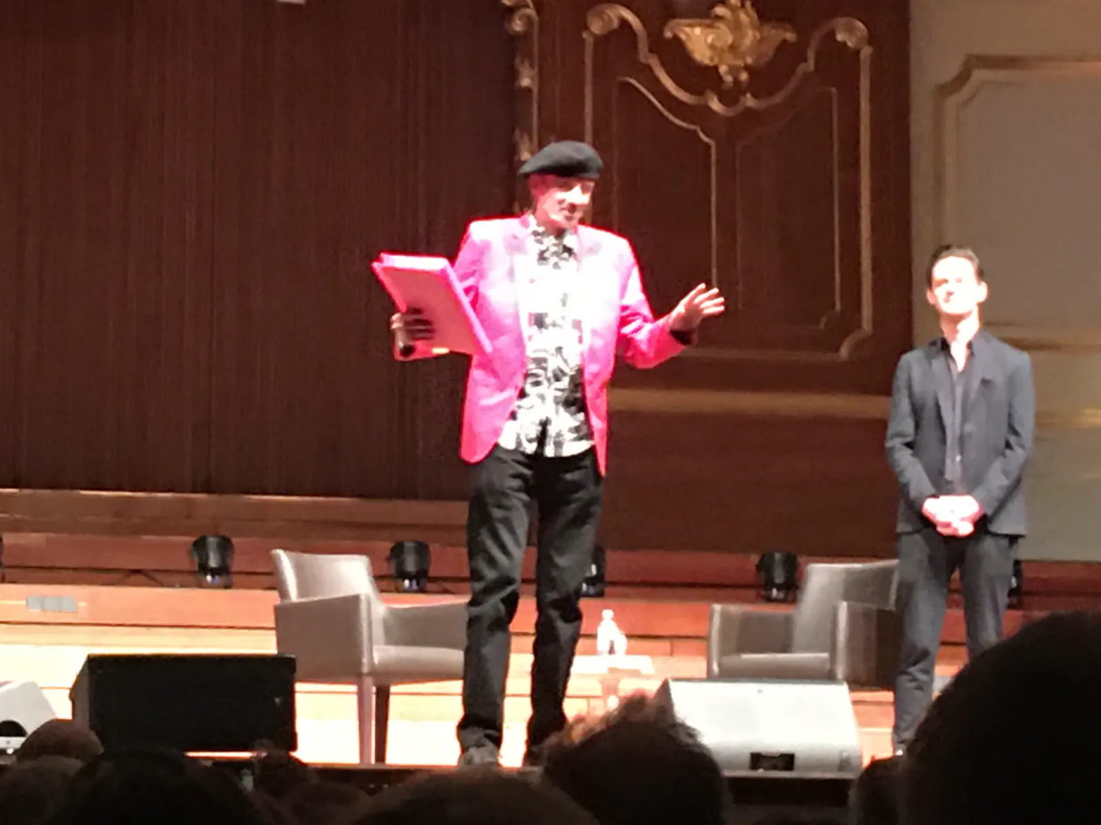 Der Schriftsteller T.C. Boyle mit Mütze und Manuskript vor Publikum