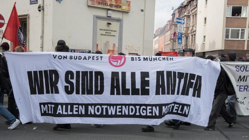 weißes Transpi mit schwarzer Schrift "Wir sind alle Antifa - mit allen notwendigen Mitteln", Demo in Nürnberg anlässlich des Urteils gegen Hanna